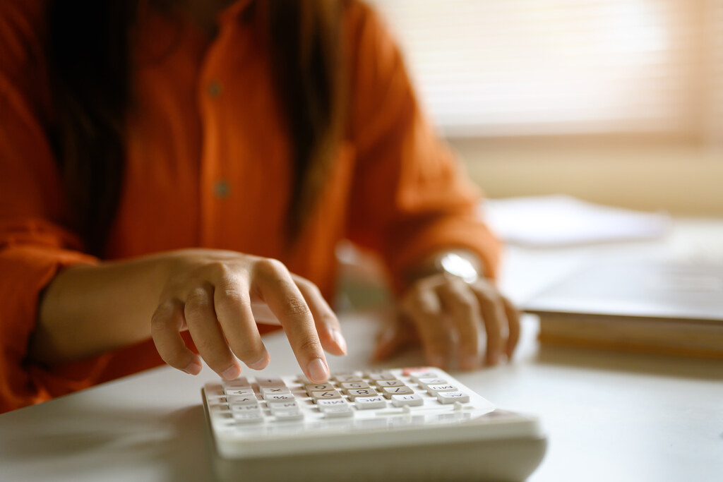 A woman calculating the return on an investment on a calculator
